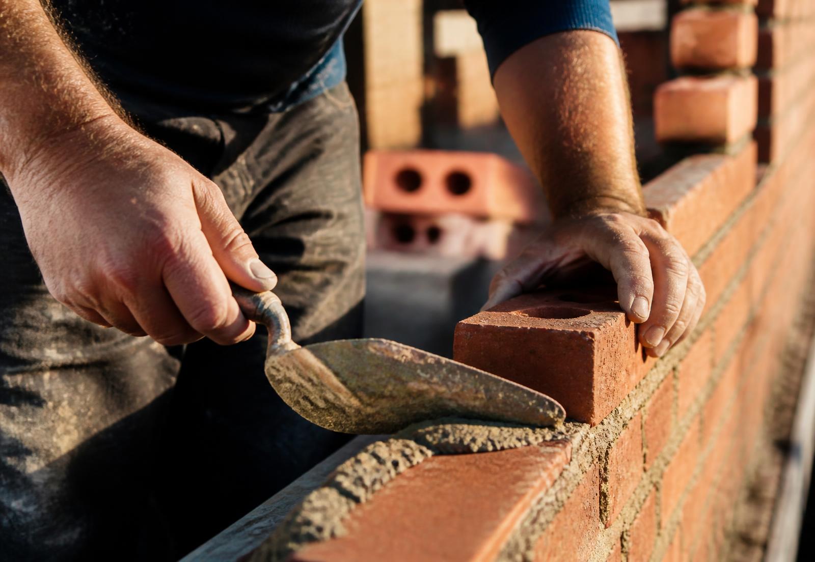 Mason laying brick with a trowel